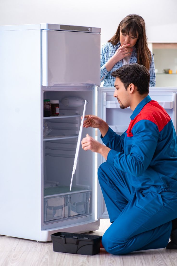 Technician repairing refrigerator
